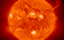 Image of the Sun with a large solar flare erupting and numerous sunspots.