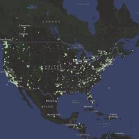 This map of North America shows the ocean colored blue and land in shades of green. Hundreds of green dots are plotted across the land to show the locations of air quality sensors.