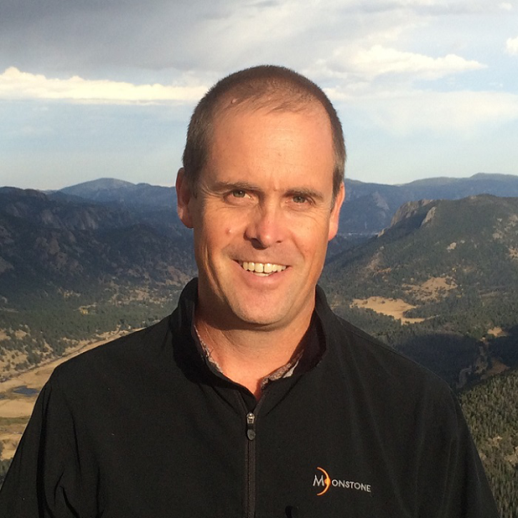 Headshot of Johnson standing outside with mountains in the background