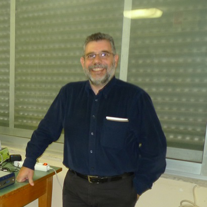 Pavlis standing in his lab wearing a blue longsleeve shirt