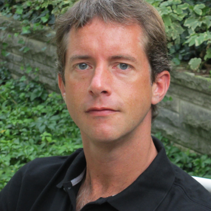 Headshot of Lars Bromley outside wearing a black polo shirt