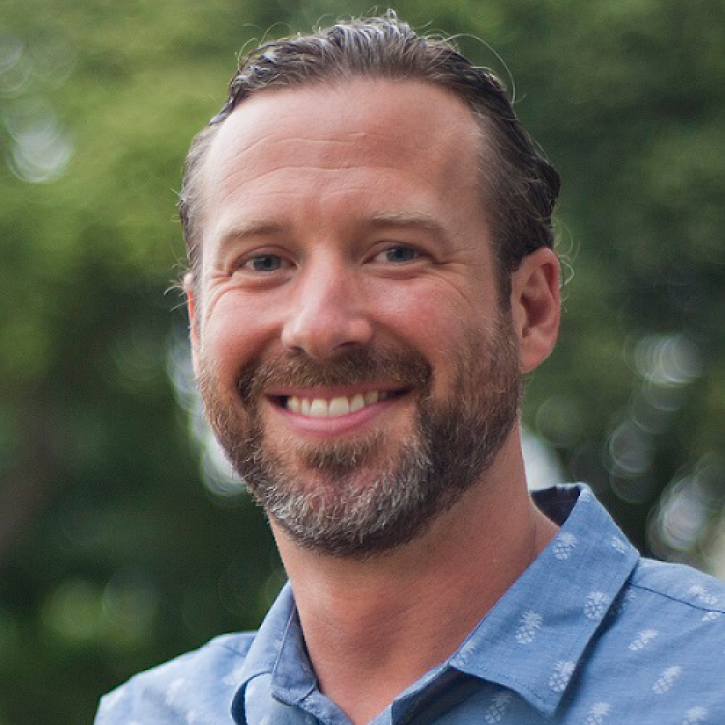 headshot of philip thompson standing outside wearing a hawiian shirt