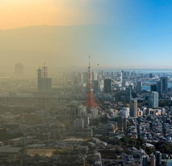 An aerial image of a sunny day in New York City wherein half of the image in covered in a translucent smog.