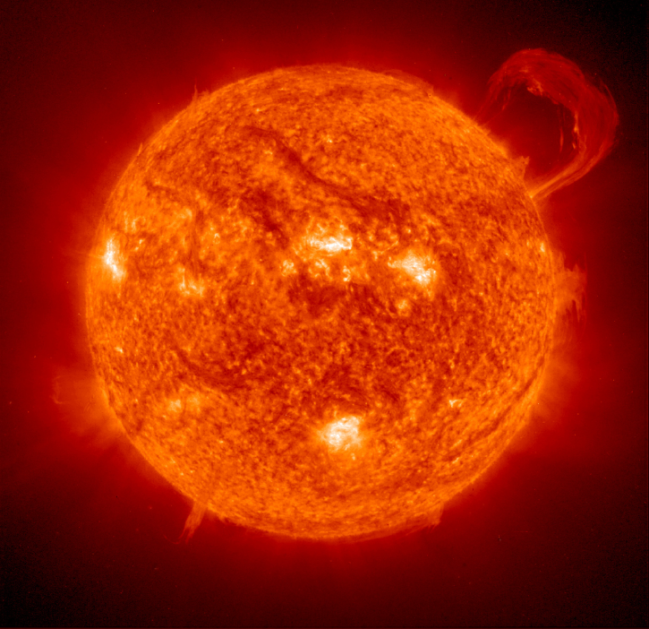 Image of the Sun with a large solar flare erupting and numerous sunspots