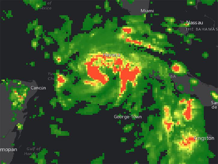 Hurricane Ida is shown in bright swirling greens, yellows, and oranges against a dark background