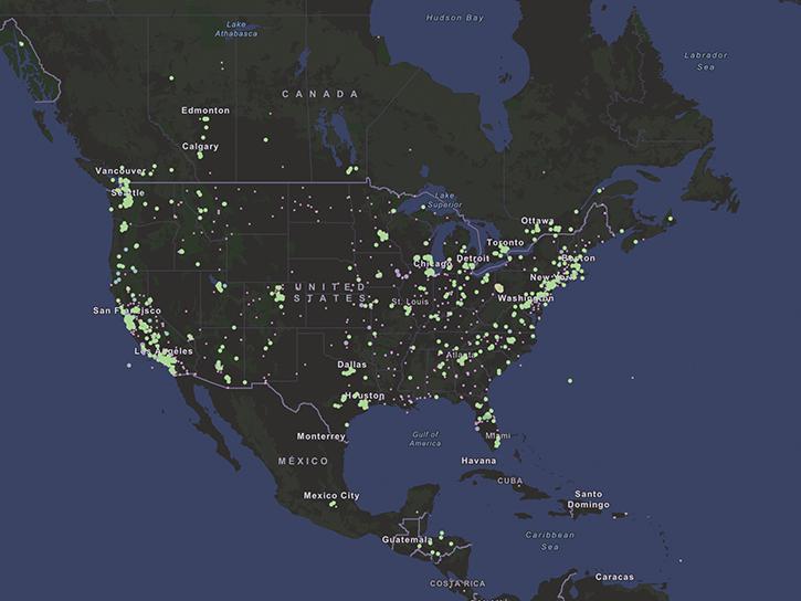 This map of North America shows the ocean colored blue and land in shades of green. Hundreds of green dots are plotted across the land to show the locations of air quality sensors.
