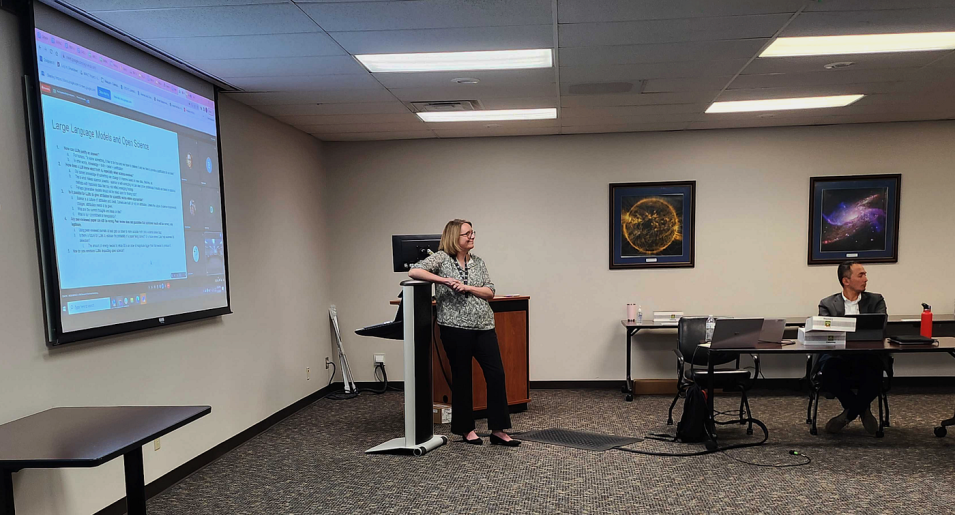 Kaylin Bugbee stands at a podium in front of a large projector screen