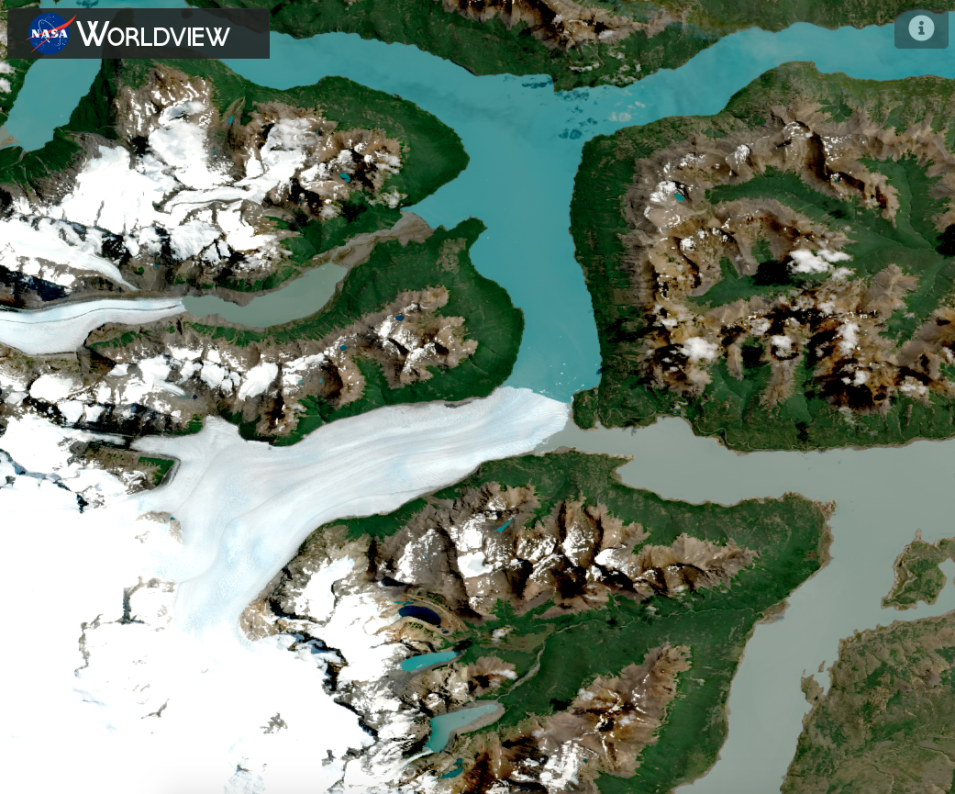 Worldview satellite image showing the Perito Moreno Glacier in Argentina, with the bright white glacier in the bottom left of the frame, offset by blue water and green-brown land. 