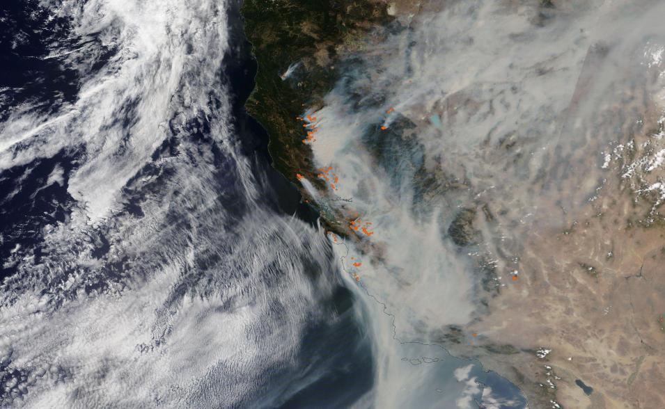 coast of California with orange dots indicating fires; white smoke blows to south