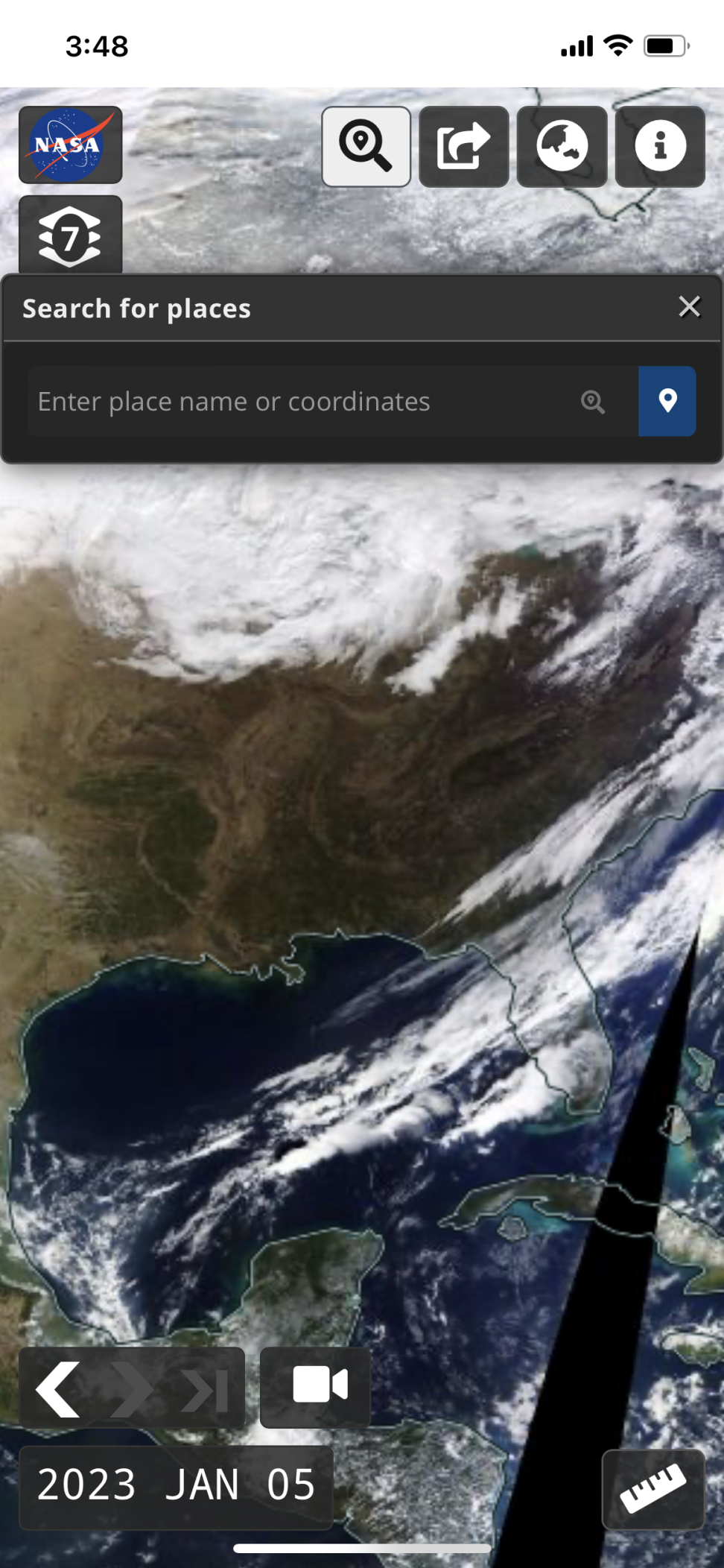 Screenshot of Worldview on a mobile device showing satellite imagery of Earth, with blue ocean, green-brown land, and white clouds. 