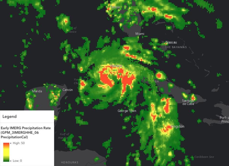 Hurricane Ida is shown in bright swirling greens, yellows, and oranges against a dark background