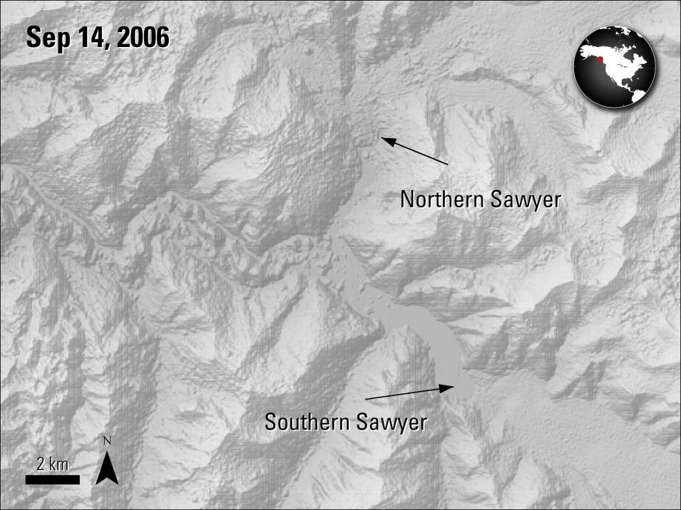 This is a grayscale topographical image of the icefield depicting many ridges and valleys. The two-part Sawyer glacier is visible in the middle, at first running north and south and labeled Northern Sawyer, then turning to flow in the direction of the lower right-hand corner of the image and marked with the text Southern Sawyer. In the upper-left hand corner is the text Sep 14, 2006. In the upper right-hand image is a small, circular map of North America with a red dot marking the location in Alaska.