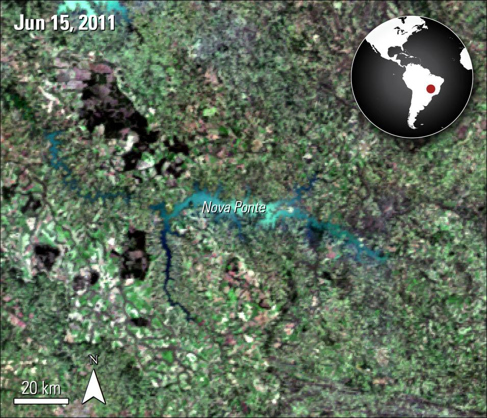 In this rectangular image is an overhead color reflectance scan of the reservoir. The landscape is mosly green with spots of red and tan mixed in as well as gray vein-like lines throughout the image. Several water bodies are present and colored black. In the upper left-hand corner is the text Jun 15, 2011. In the upper right-hand corner is a small map of South America with a red dot marking the location of the reservoir. 