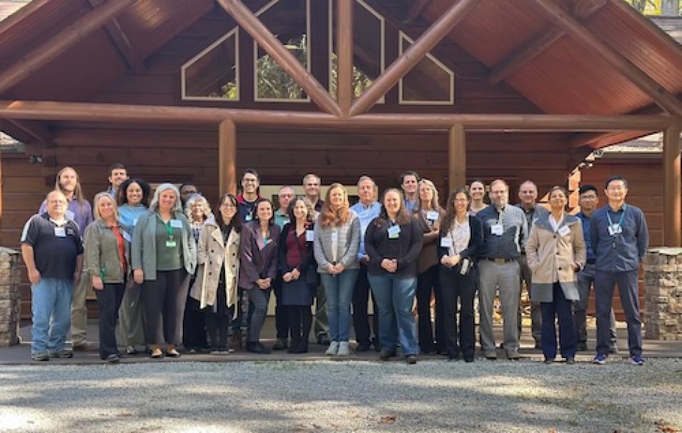 A group photo of the ORNL DAAC user working group, standing in front of a barn structure.