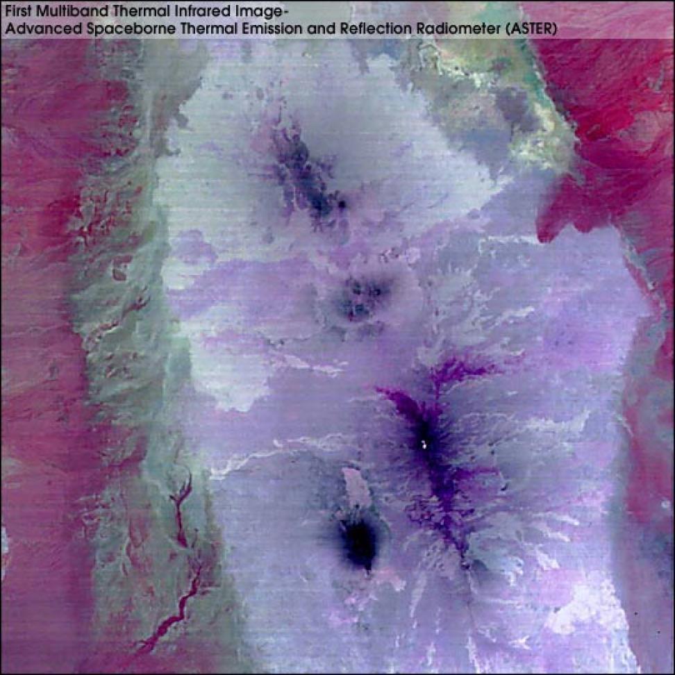 This image shows color variations from the sides of the image inward. Areas on the left and right sides are in red hues. Areas in the central part of the image are white and lavender. Dark areas are also visible in the center. There are ten very bright pixels in the lower center of the image.