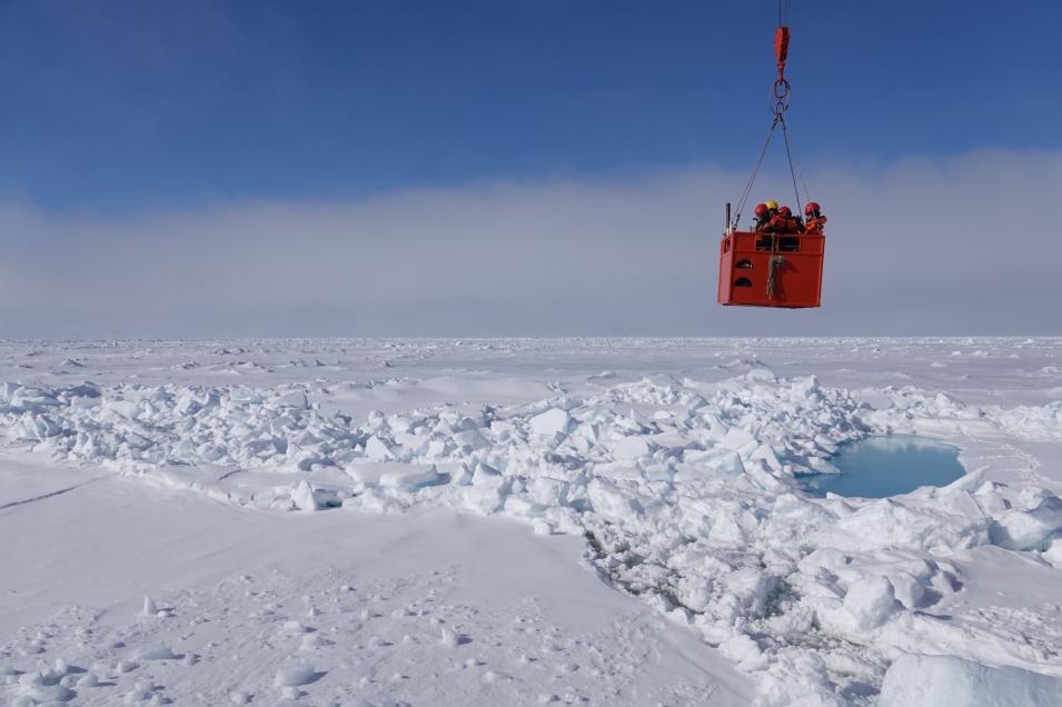 A group of scientists get hoisted back their ship after taking measurements on Arctic sea ice