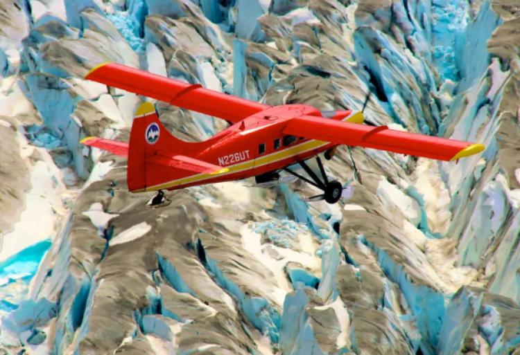 An image of an Airplane flying over rocky terrain.