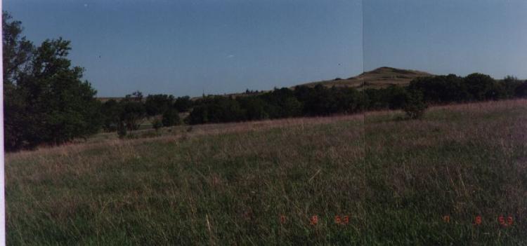 A Kansas landscape, with grass and hills beneath a blue sky.