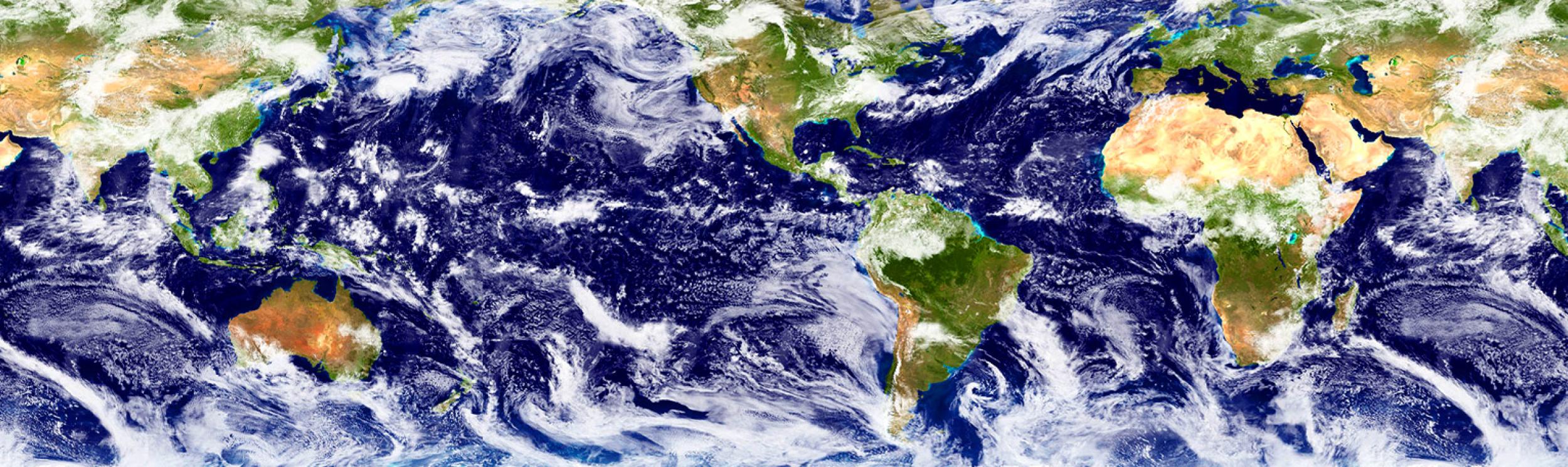 A satellite image of Earth shows land in shades of green and water in shades of blue, with swirling white clouds. 