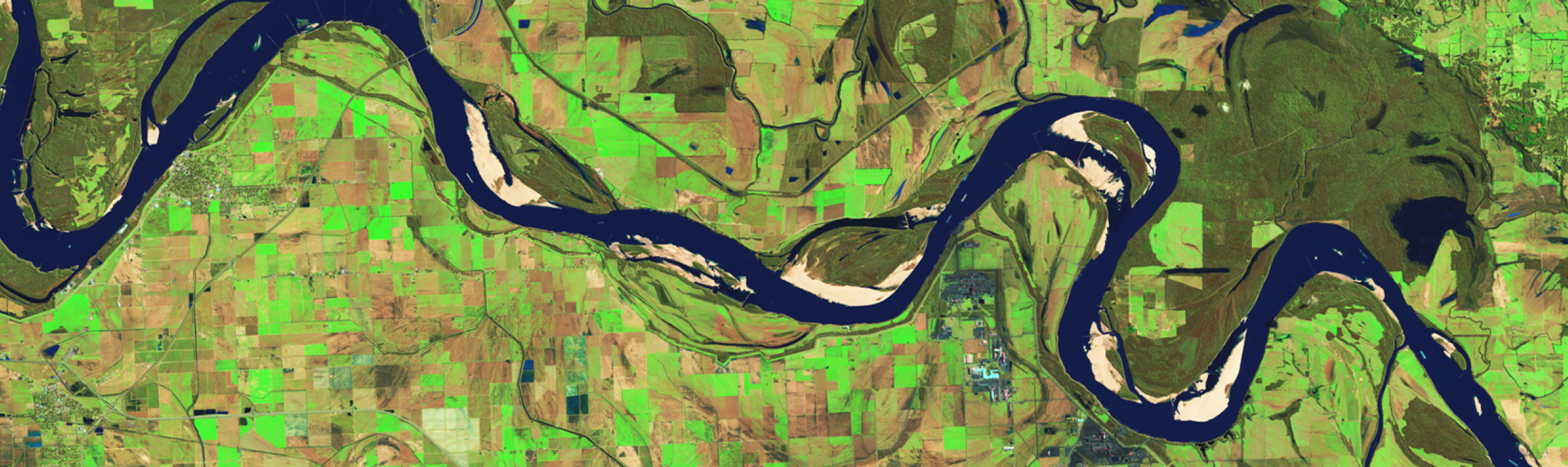The image is an aerial or satellite view of a solar farm or photovoltaic power station. These facilities are large-scale installations of solar panels used to generate electricity. 