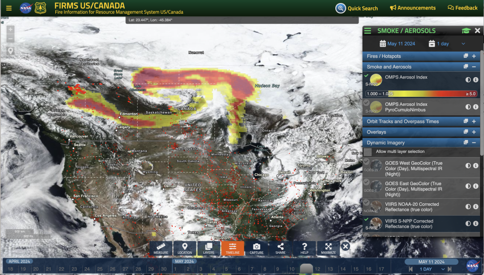 Screenshot of the US/Canada FIRMS application, showing a satellite image of North America, with smoke and fire indicated in red, orange, and yellow over Canada. Red dots across North American indicate fire hotspots.
