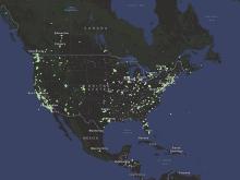 This map of North America shows the ocean colored blue and land in shades of green. Hundreds of green dots are plotted across the land to show the locations of air quality sensors.